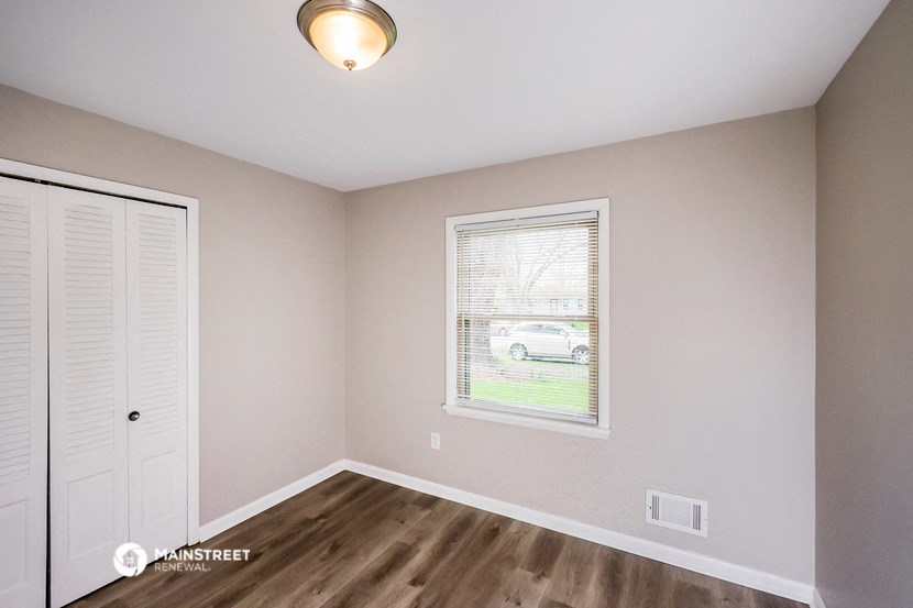 the interior of a bedroom with a door and a window