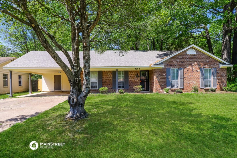 a brick house with a tree in the front