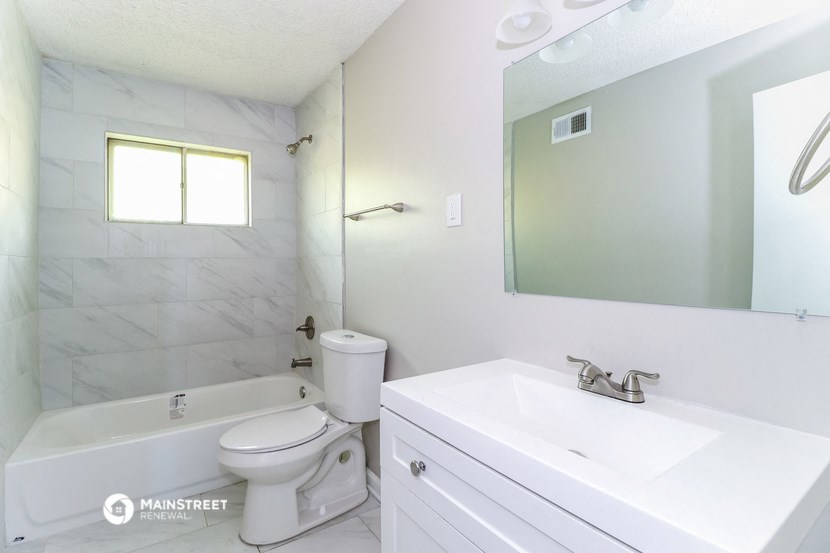 a bathroom with a sink toilet and a mirror