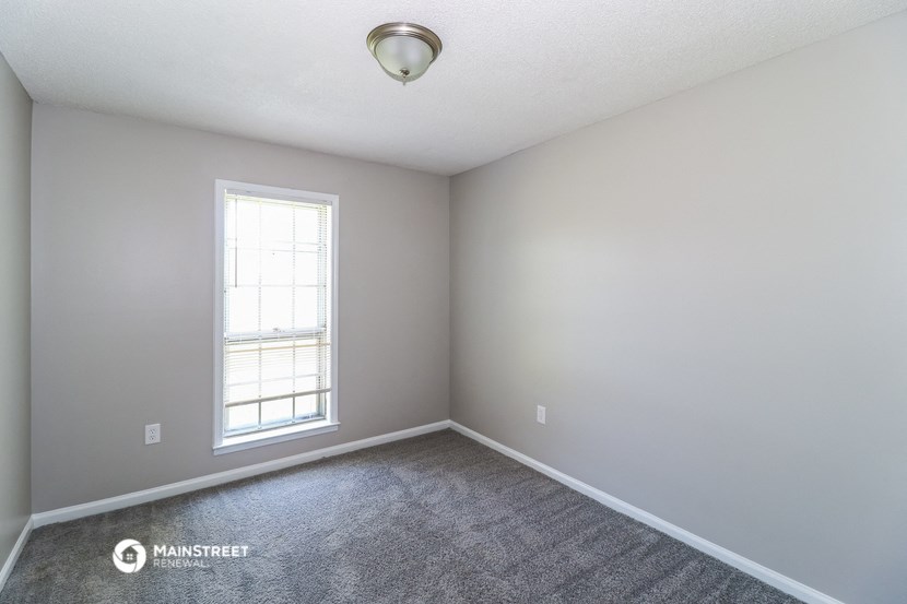 an empty room with carpet and a window