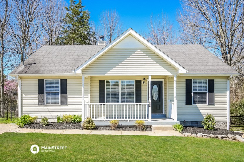 a white house with black shutters and a front porch