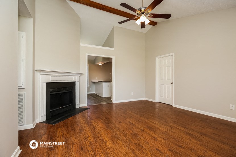 a living room with a fireplace and a ceiling fan