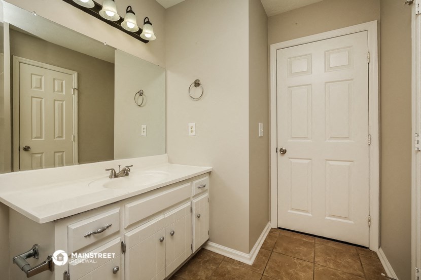 the master bathroom has a large mirror and a large sink