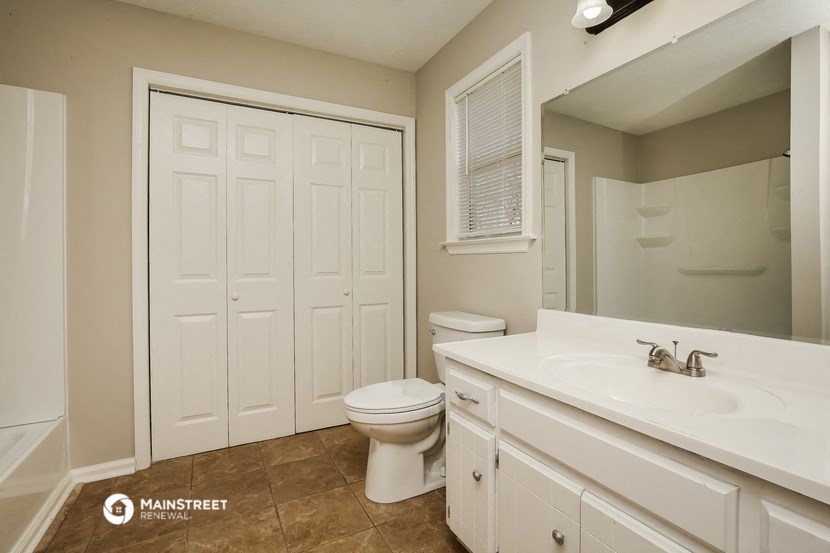 a bathroom with a toilet and a sink and a mirror