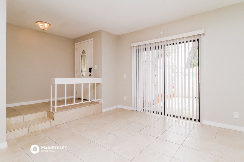 an empty living room with sliding glass doors to a patio