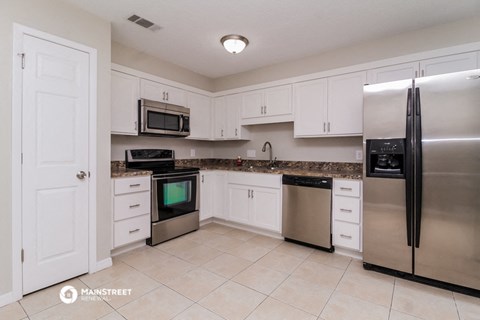a kitchen with stainless steel appliances and white cabinets