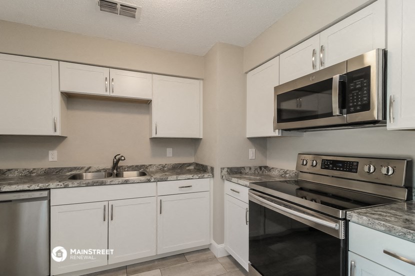 a kitchen with white cabinets and stainless steel appliances