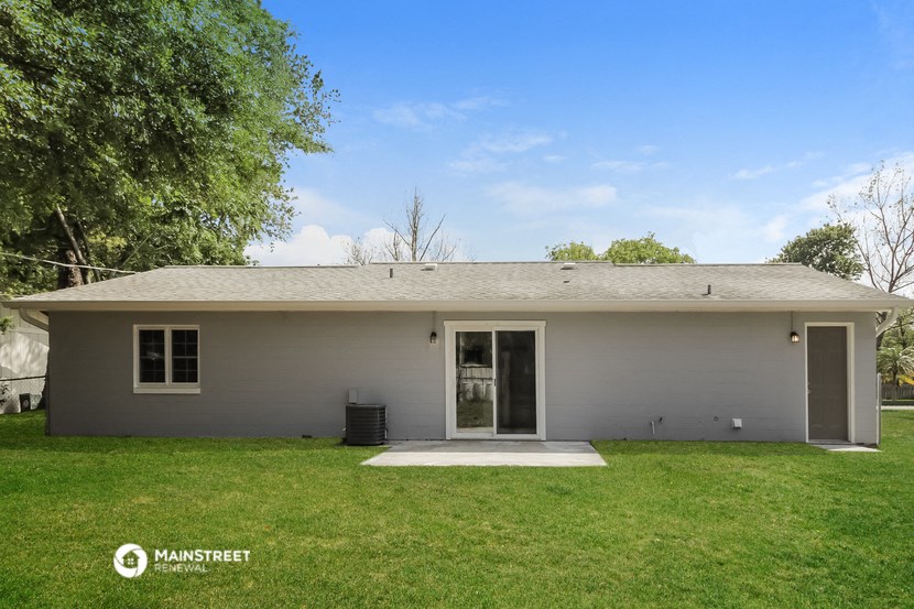 a small white house with a yard and a tree
