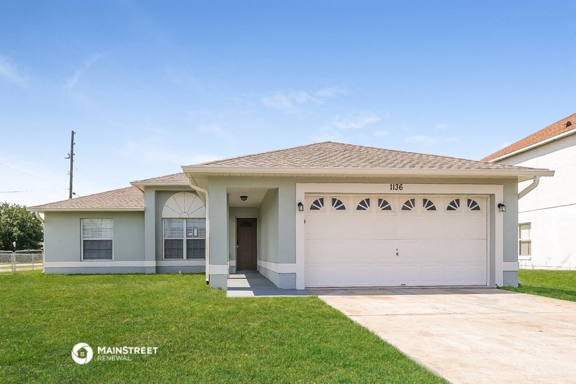 a white house with a driveway and a garage door