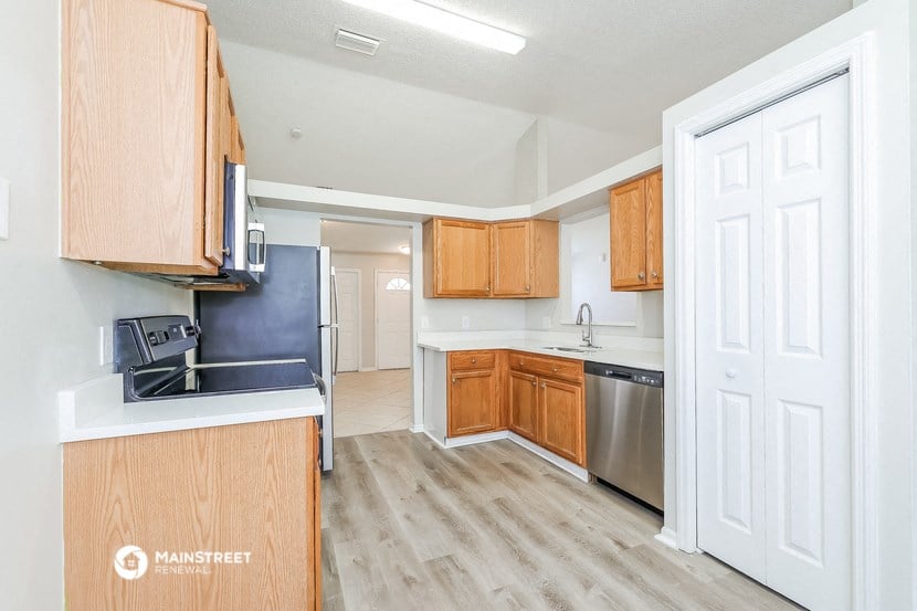 an empty kitchen with wooden cabinets and stainless steel appliances