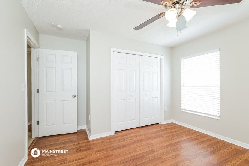 a bedroom with two closets and a ceiling fan