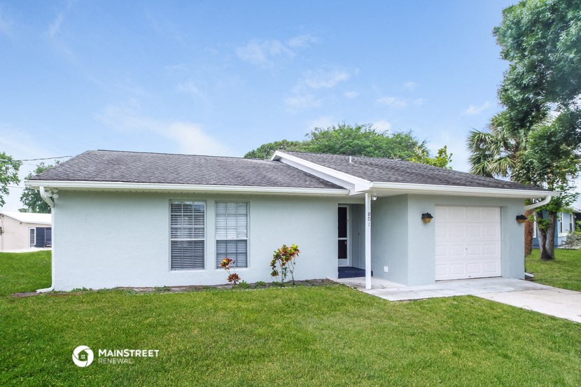 a white house with a lawn and a white garage door