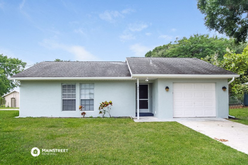 a white house with a lawn and a white garage door