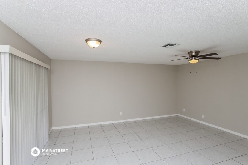 a living room with a ceiling fan and a tiled floor