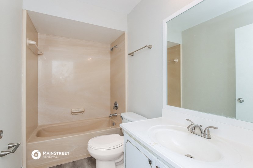 a bathroom with a sink toilet and shower and a mirror