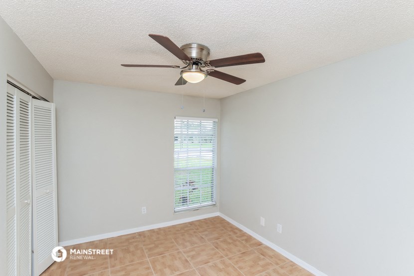 a living room with a ceiling fan and a window