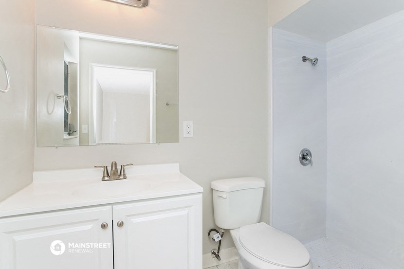 a bathroom with a toilet and a sink and a mirror