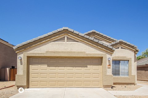 a tan brick house with a garage door