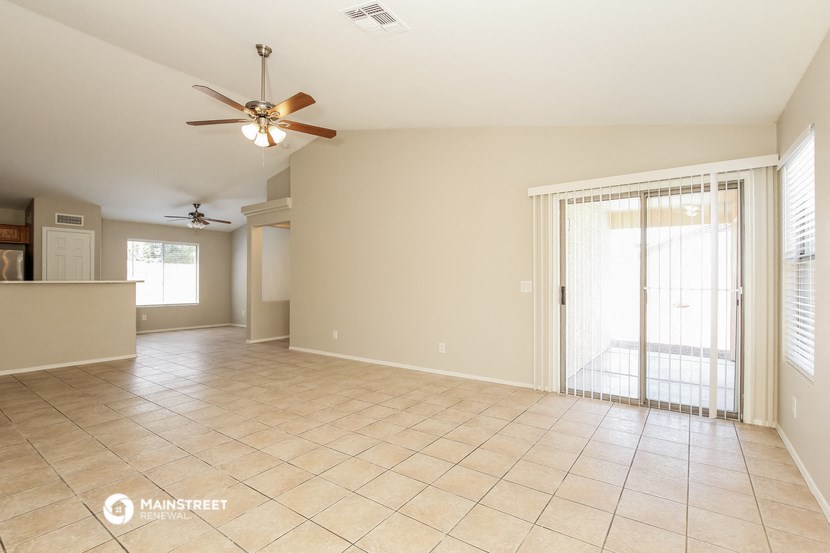 an empty living room with a sliding glass door to the patio