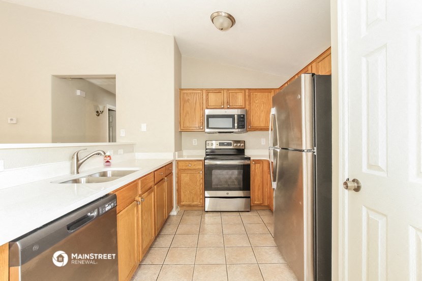 a kitchen with wooden cabinets and stainless steel appliances