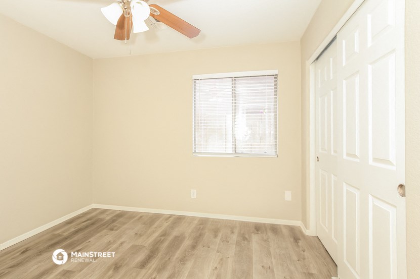 an empty room with a ceiling fan and a window