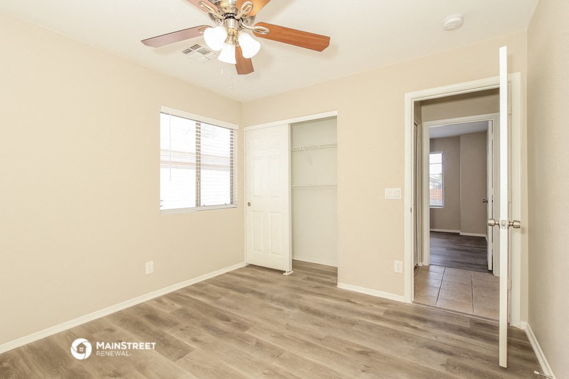an empty room with a ceiling fan and a closet