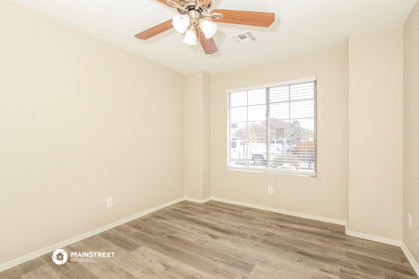 a living room with a ceiling fan and a window