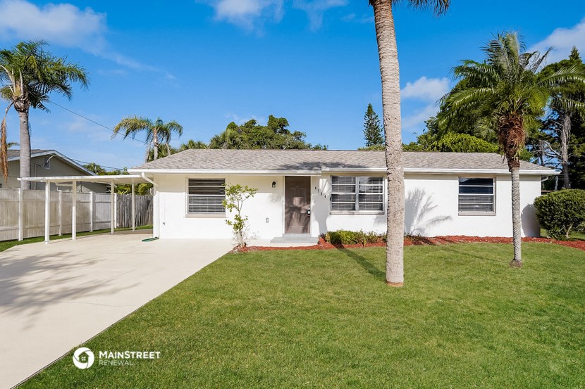 a white house with palm trees in front of it