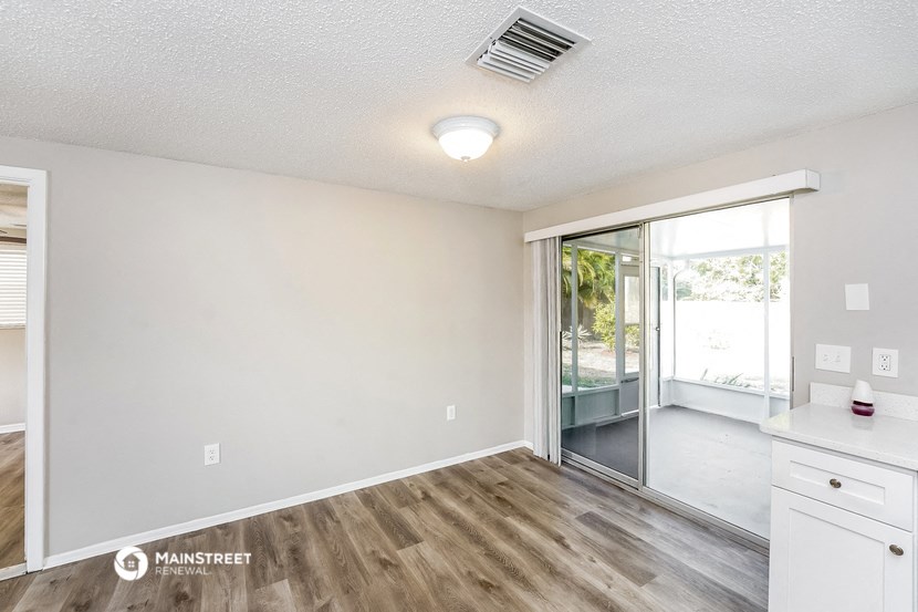 the spacious living room and dining room with a sliding glass door to the patio