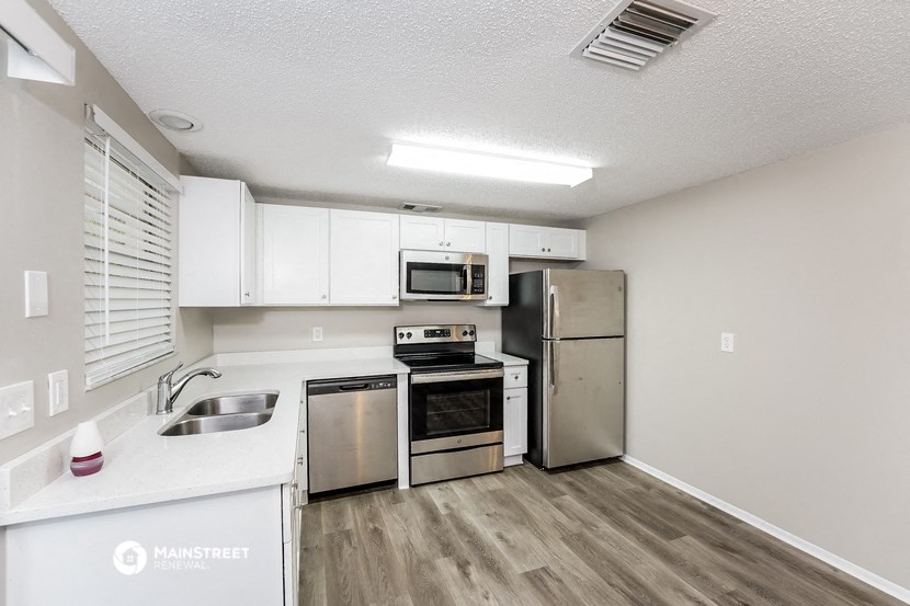a kitchen with stainless steel appliances and white cabinets