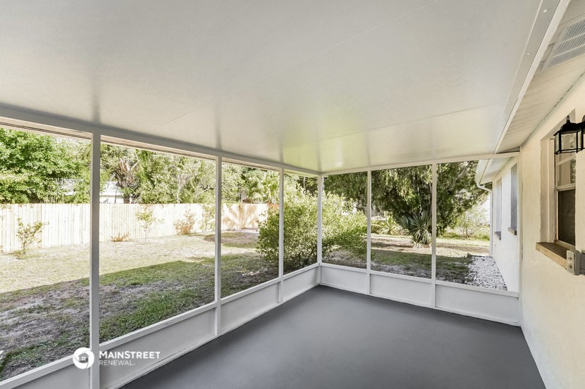 a living room with large windows and a view of the yard
