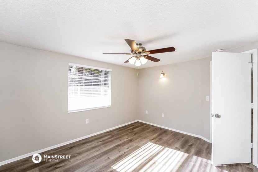 a living room with a ceiling fan and a window