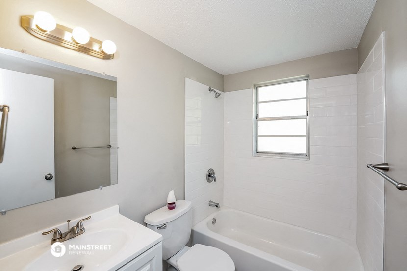 a white bathroom with a tub and a sink and a toilet