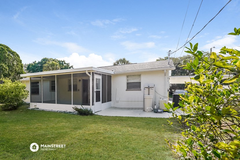 a small white house with a yard and a lawn