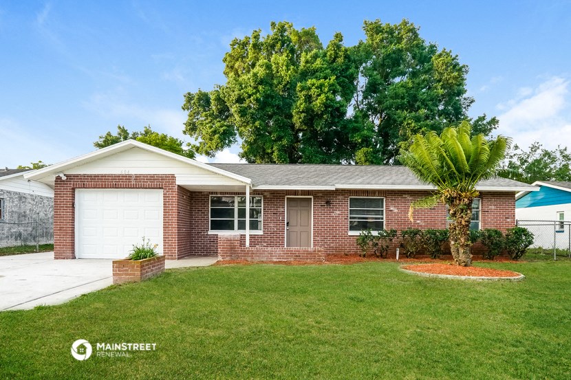 a brick house with a lawn and a white garage door