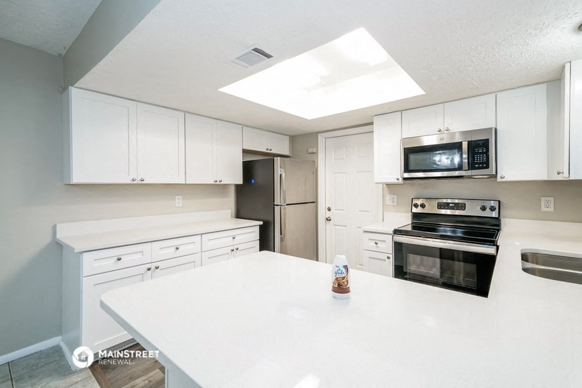 a kitchen with white cabinets and a white counter top
