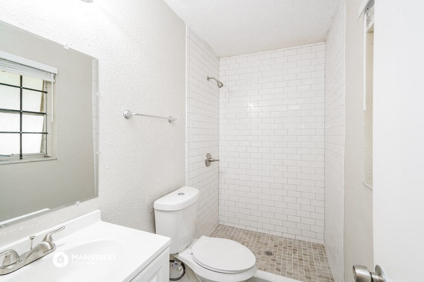 a white bathroom with a toilet and a sink