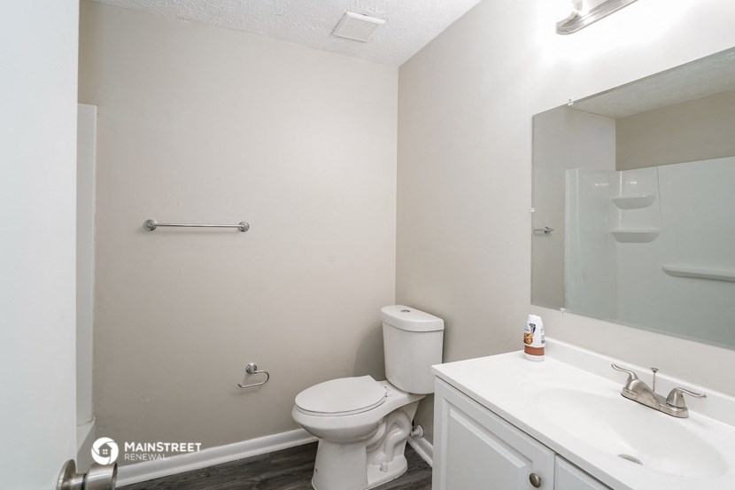 a white bathroom with a toilet and a sink