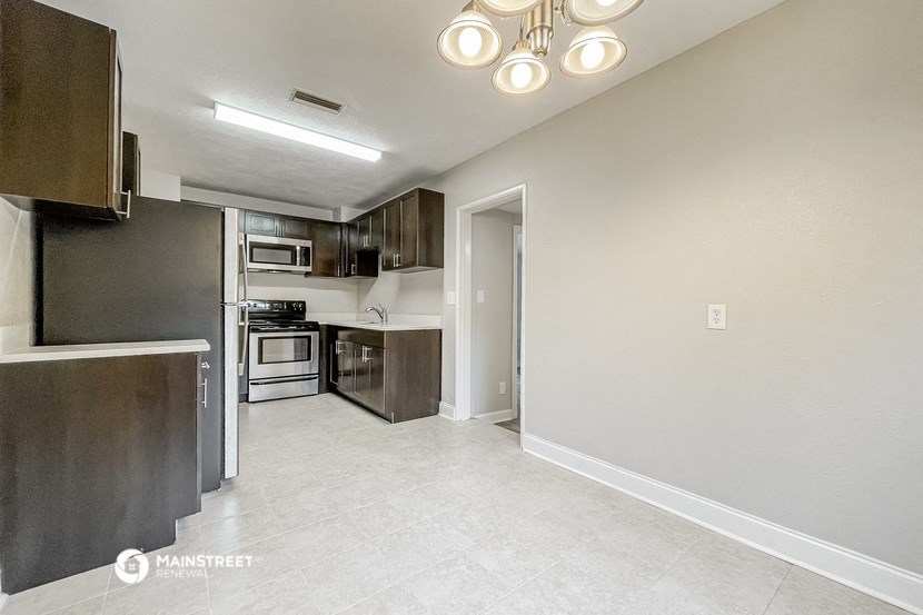 a renovated kitchen with stainless steel appliances and white tile flooring
