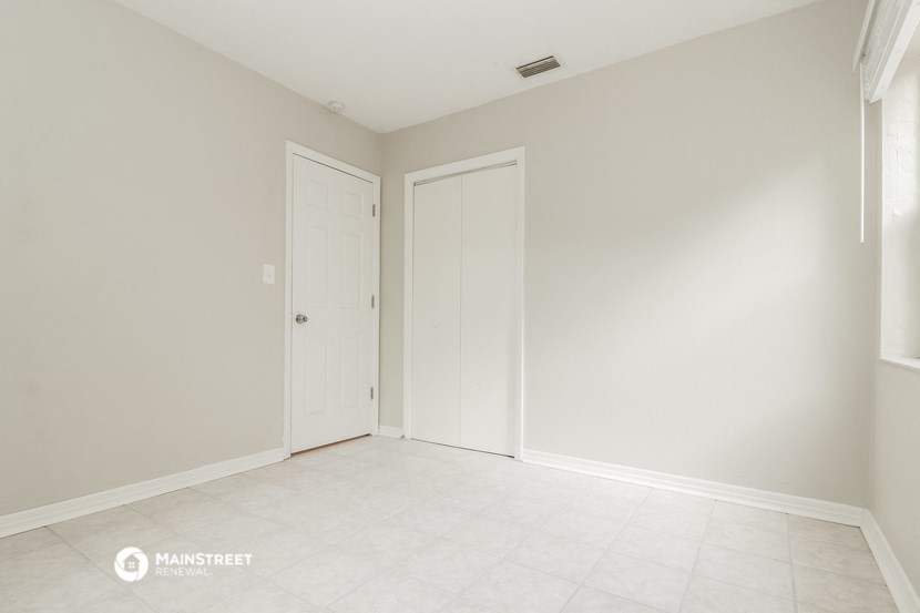 an empty room with two doors and a tiled floor