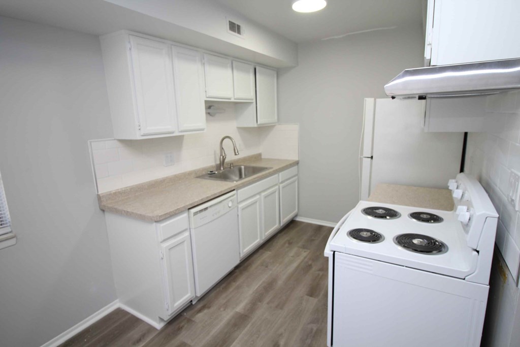 a kitchen with white cabinets and a stove and refrigerator