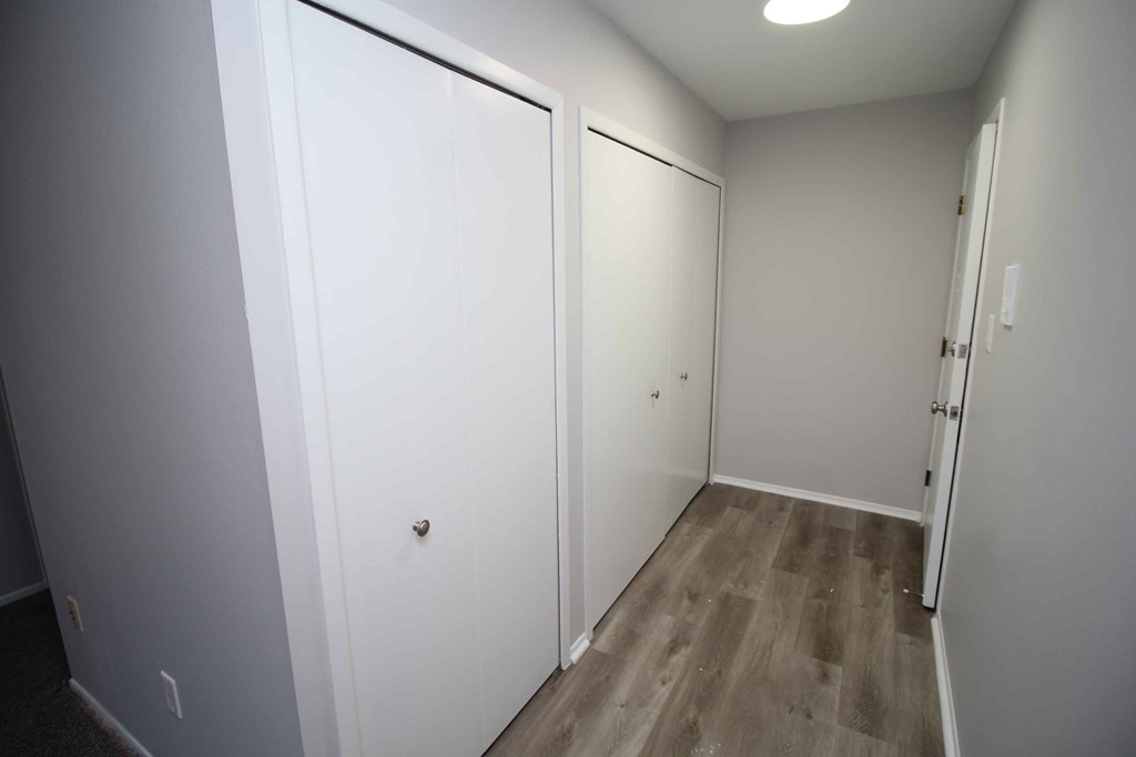 a pair of white closets in a room with wood floors
