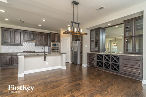 a kitchen with dark wood cabinets and a white counter top