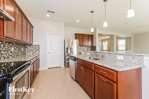 A kitchen with brown cabinets and a granite counter top.
