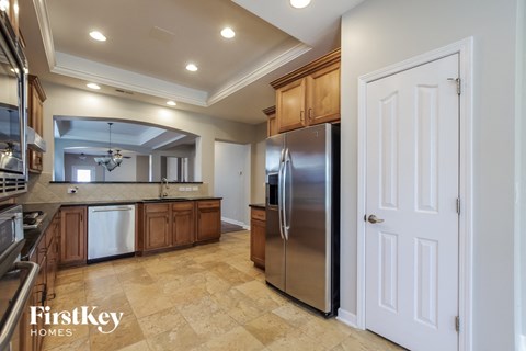 a large kitchen with stainless steel appliances and wooden cabinets