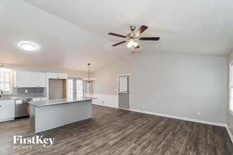 A spacious room with a ceiling fan and wooden flooring.