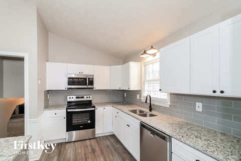 A kitchen with white cabinets and a stainless steel dishwasher.