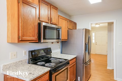 A kitchen with wooden cabinets and a stainless steel refrigerator.