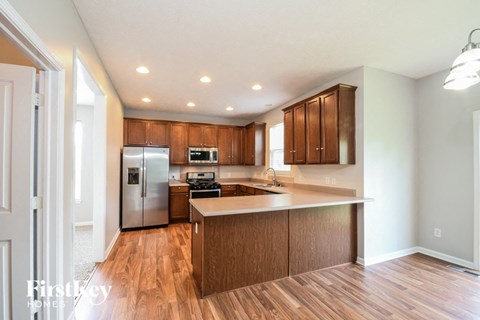 A kitchen with wooden cabinets and a refrigerator.