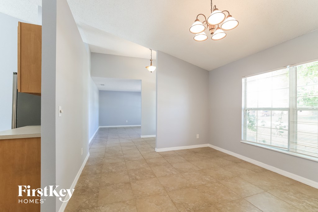 A room with a tile floor and a window with blinds.